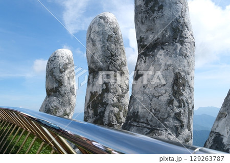 Da Nang, Vietnam Golden Bridge stone hand bridge and mountain view observatory at the Ba Na Hills Sunworld in DaNang Vietnam Da Nang, Vietnam Golden Bridge stone hand bridge and mountain view observatory at the Ba Na Hills Sunworld in DaNang Vietnam 129263787