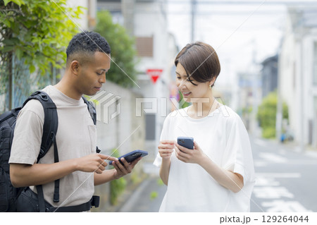 外国人の男性に道を説明をする女性 外国人の男性に道を説明をする女性 129264044