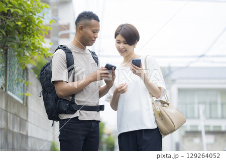 外国人の男性に道を説明をする女性　 129264052