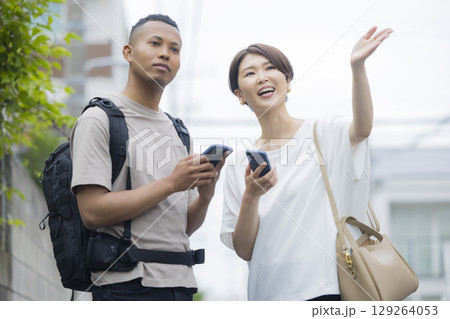 外国人の男性に道を説明をする女性　 129264053
