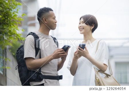 外国人の男性に道を説明をする女性　 129264054