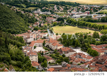 Picturesque View Of Vipava From Castle Ruins: Red-Tiled Rooftops And Church Tower Nestled In Green Valley With Blooming Flowers In Foreground And Rolling Fields In Background, Slovenia Picturesque View Of Vipava From Castle Ruins: Red-Tiled Rooftops And Church Tower Nestled In Green Valley With Blooming Flowers In Foreground And Rolling Fields In Background, Slovenia 129264278