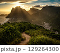 Golden Sunset Over Rio De Janeiro From Two Brothers Mountain: Dramatic Sunbeams Streaming Through Coastal Peaks Above The Atlantic Ocean And Leblon Beach 129264300