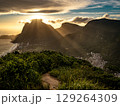 Golden Sunset Over Rio De Janeiro From Two Brothers Mountain: Dramatic Sunbeams Streaming Through Coastal Peaks Above The Atlantic Ocean And Leblon Beach 129264309
