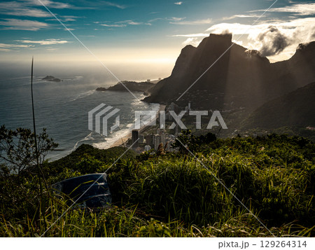 Golden Sunset Over Rio De Janeiro From Two Brothers Mountain: Dramatic Sunbeams Streaming Through Coastal Peaks Above The Atlantic Ocean And Leblon Beach Golden Sunset Over Rio De Janeiro From Two Brothers Mountain: Dramatic Sunbeams Streaming Through Coastal Peaks Above The Atlantic Ocean And Leblon Beach 129264314