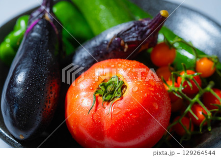 水滴のついた瑞々しい夏野菜の盛り合わせ・トマト・ナス・キュウリ・ズッキーニ・ピーマン 129264544
