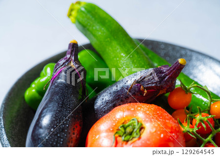 水滴のついた瑞々しい夏野菜の盛り合わせ・トマト・ナス・キュウリ・ズッキーニ・ピーマン 129264545