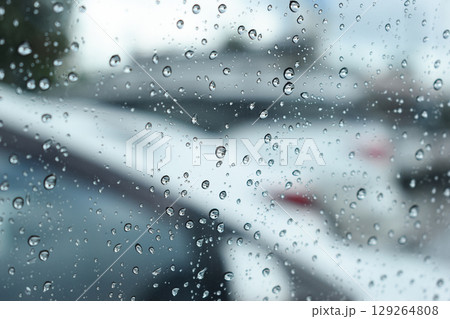 water drop on mirror in defocused car parking background water drop on mirror in defocused car parking background 129264808