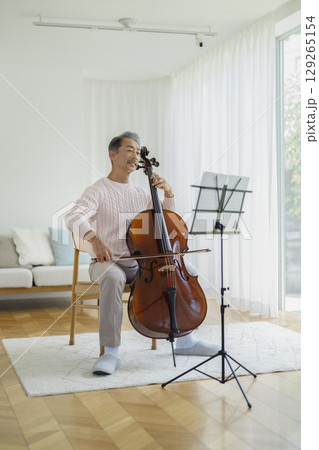 自宅でチェロを弾く60代の男性 129265154