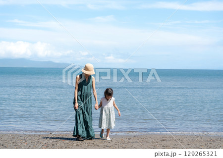 海辺で手をつなぐ親子 129265321