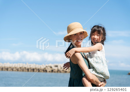 海辺で抱っこをする親子 129265401