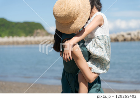 海辺で抱っこをする親子 海辺で抱っこをする親子 129265402