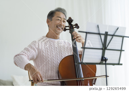 チェロを弾く笑顔の60代の男性 129265499