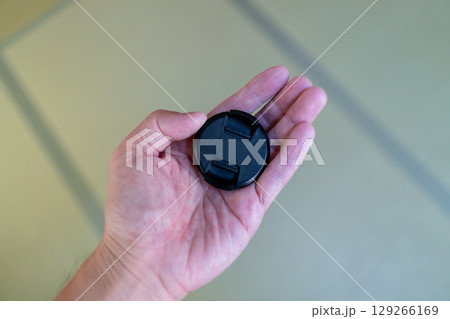 レンズキャップを持つ手 129266169