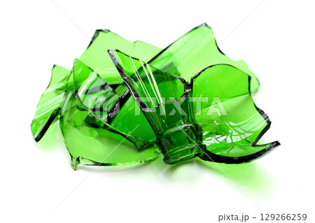 Sharp green glass shards scattered on a white background. 129266259