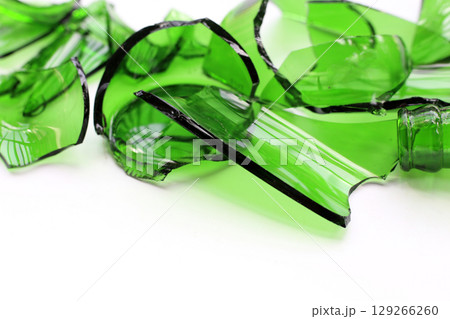 Sharp green glass shards scattered on a white background. 129266260