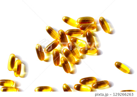 Golden fish oil capsules on white background. 129266263