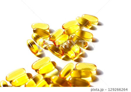 Golden fish oil capsules on white background. 129266264