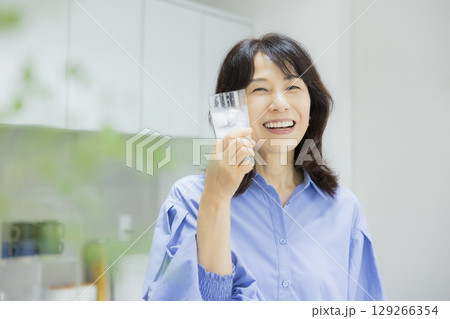 キッチンで水を飲む女性　 129266354