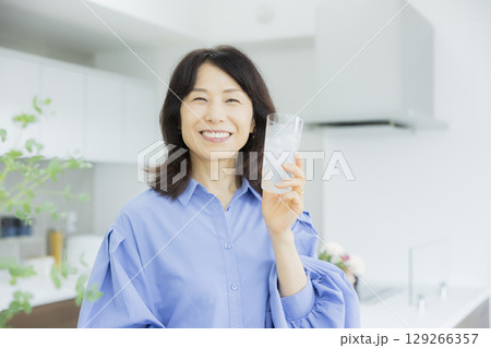 キッチンで水を飲む女性　 129266357