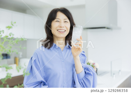 キッチンで水を飲む女性　 129266358
