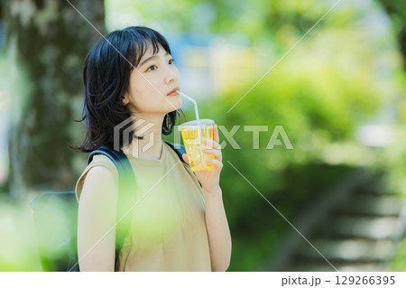 緑の中を歩く女性 129266395