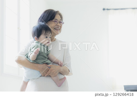 おばあちゃんに抱っこされる赤ちゃん おばあちゃんに抱っこされる赤ちゃん 129266418