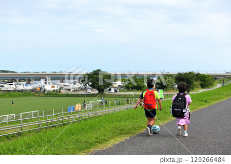 平塚馬入サッカー場の土手を歩く兄と妹 129266484