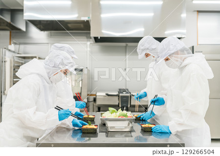 お弁当の盛り付けをする男女(食品工場,食品加工,食品衛生) お弁当の盛り付けをする男女(食品工場,食品加工,食品衛生) 129266504