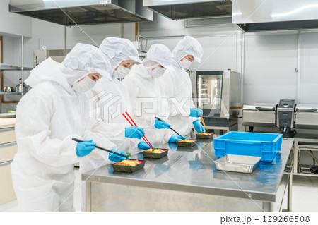 お弁当の盛り付けをする男女（食品工場,食品加工,食品衛生） 129266508
