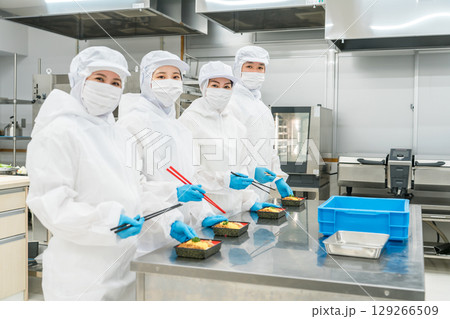 お弁当の盛り付けをする男女(食品工場,食品加工,食品衛生) お弁当の盛り付けをする男女(食品工場,食品加工,食品衛生) 129266509