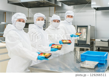 お弁当の盛り付けをする男女（食品工場,食品加工,食品衛生） 129266511