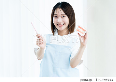 歯磨き指導をする歯科スタッフの女性 129266533