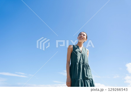 青空の下に立つワンピースの女性 青空の下に立つワンピースの女性 129266543