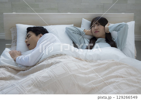 ベッドでいびきをかきながら眠る若い男性 ベッドでいびきをかきながら眠る若い男性 129266549