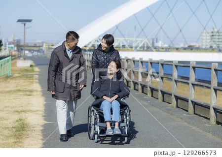 車椅子の女性と家族 129266573