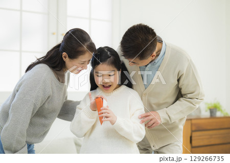 祖父母からお小遣いをもらう小学生 129266735