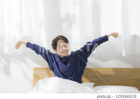 ベッドで伸びをする女性 ベッドで伸びをする女性 129266818