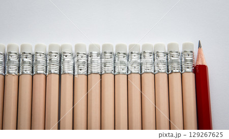 Standing Out from the Crowd. One Red Pencil Among Identical Erasers Standing Out from the Crowd. One Red Pencil Among Identical Erasers 129267625