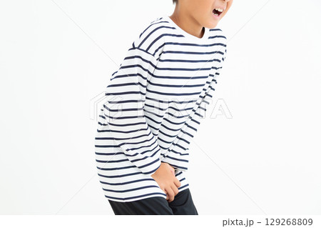 股間を押さえておしっこを我慢する小学生の男の子 129268809