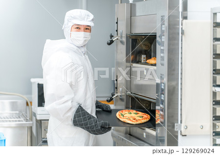 パン工場,食品工場で働く防塵服,クリーンスーツを着た製造スタッフの男性 129269024