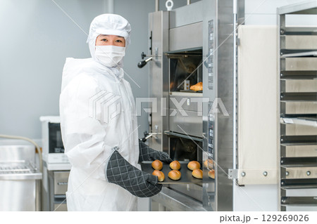 パン工場,食品工場で働く防塵服,クリーンスーツを着た製造スタッフの男性 129269026