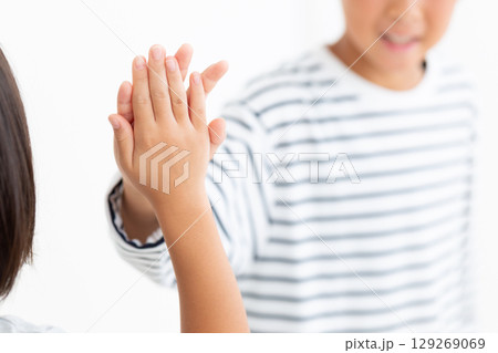 友達とハイタッチをする小学生の男の子 129269069