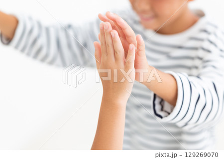 友達とハイタッチをする小学生の男の子 129269070