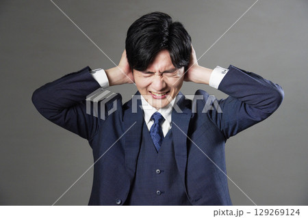ビジネスマン　耳を塞ぐ　黒背景 129269124