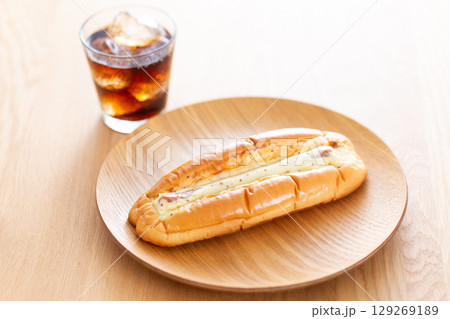 テーブルに置かれた惣菜パンのソーセージロール 129269189