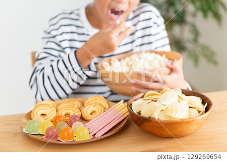 お菓子を大食いする小学生の男の子 129269654