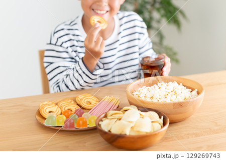 お菓子を大食いする小学生の男の子 お菓子を大食いする小学生の男の子 129269743