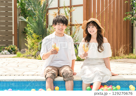 旅行先のリゾートホテルのプールサイドで遊ぶカップル・夫婦 129270676