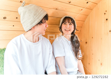 サウナに入っているTシャツ姿のカップルの若い男女 129272282
